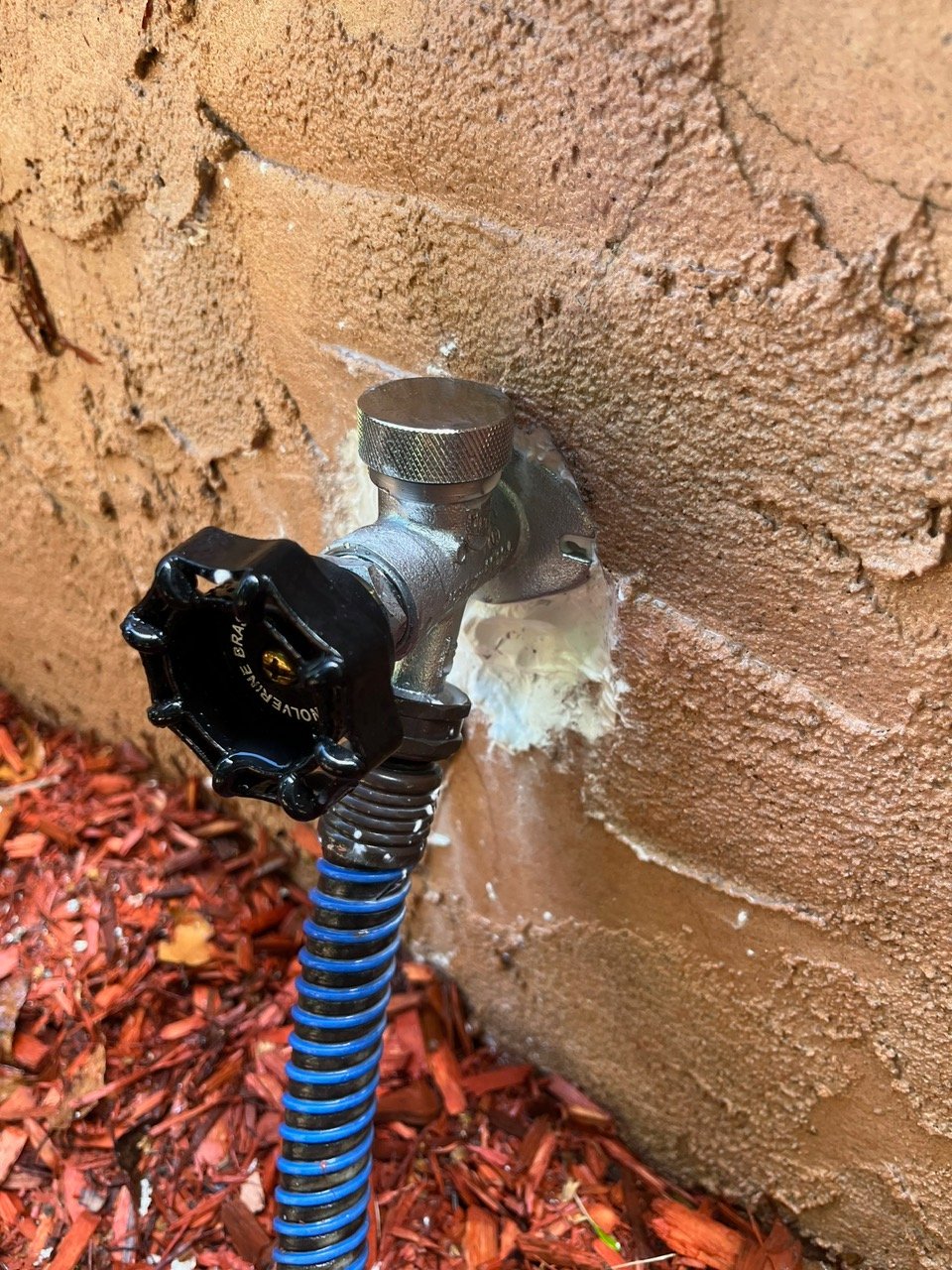 All-Plumb-Rooter plumber testing water pressure and running water outside client's home.