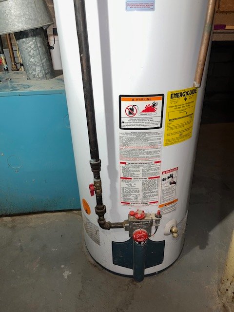 Plumber performing water heater repairs.